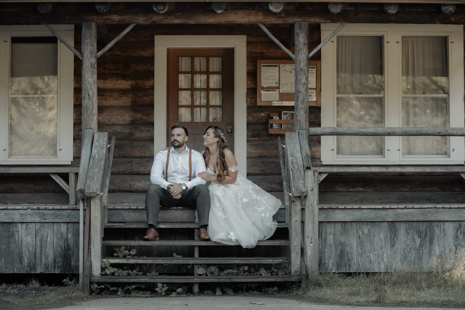 The couple on the steps of a forest cabin