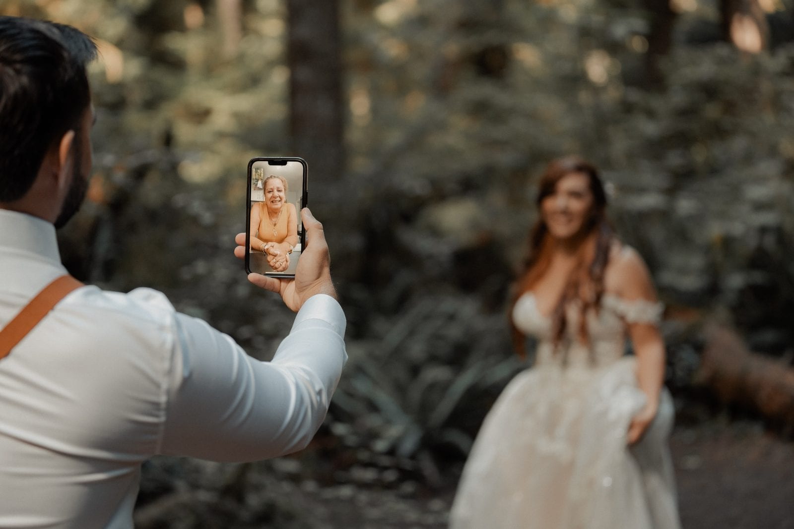 The groom showing the bride a photo on his phone