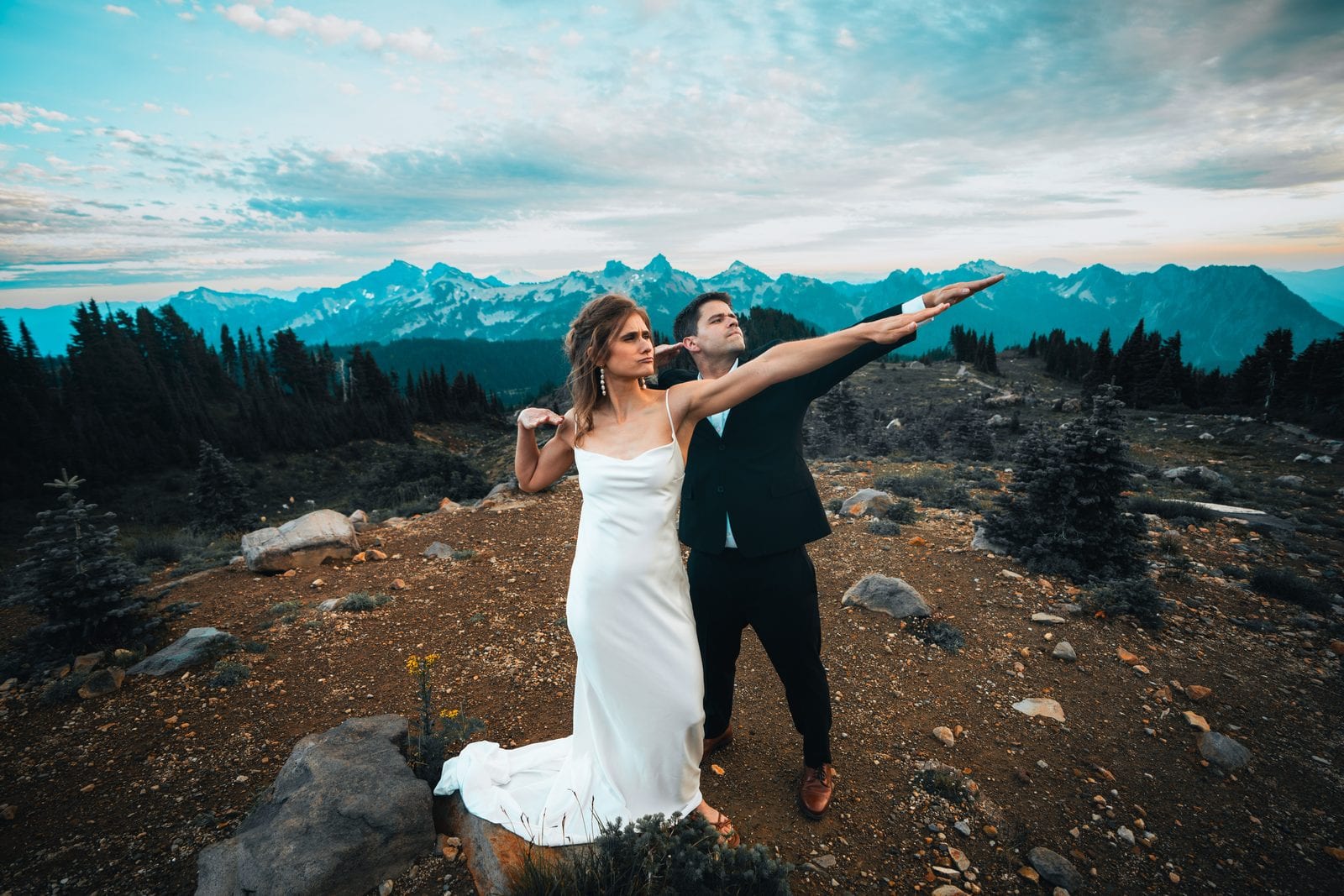 The groom pointing out across the peaks