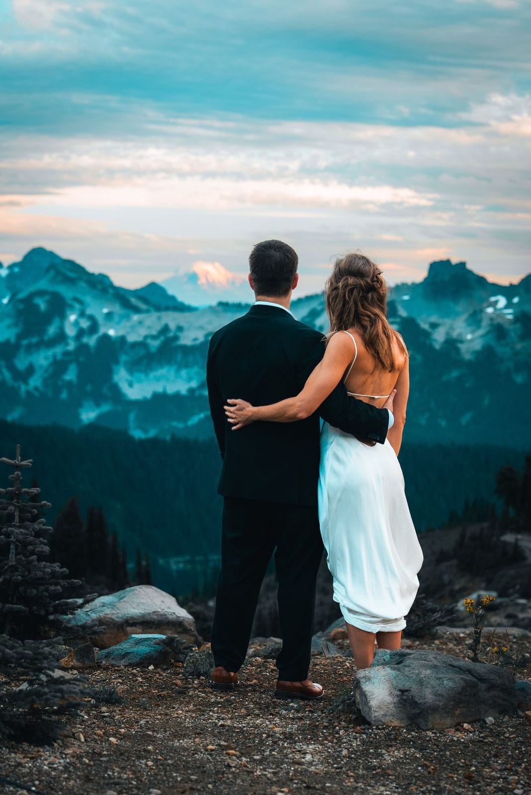 The couple looking out over the mountains at dusk