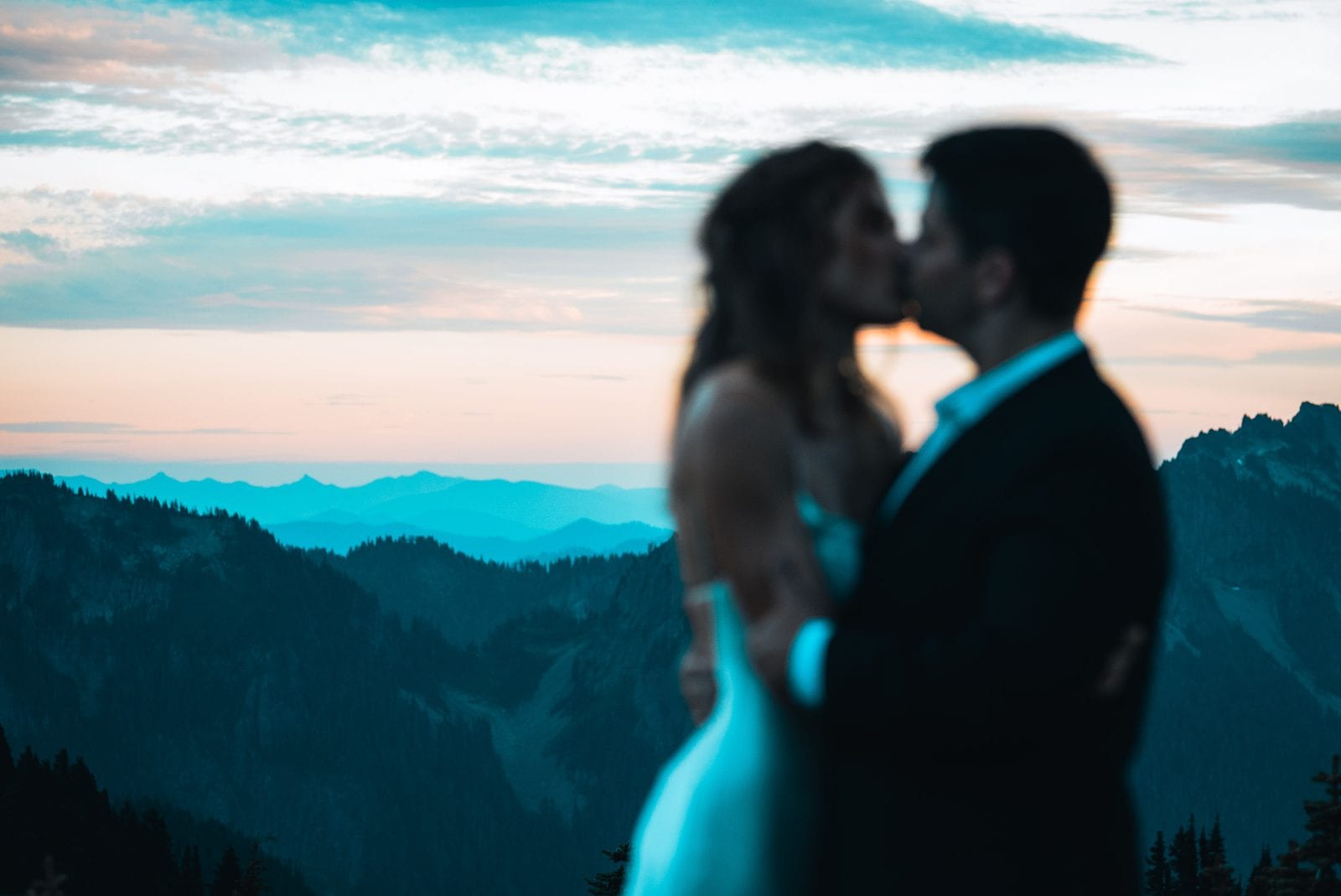 The couple kissing at sunset