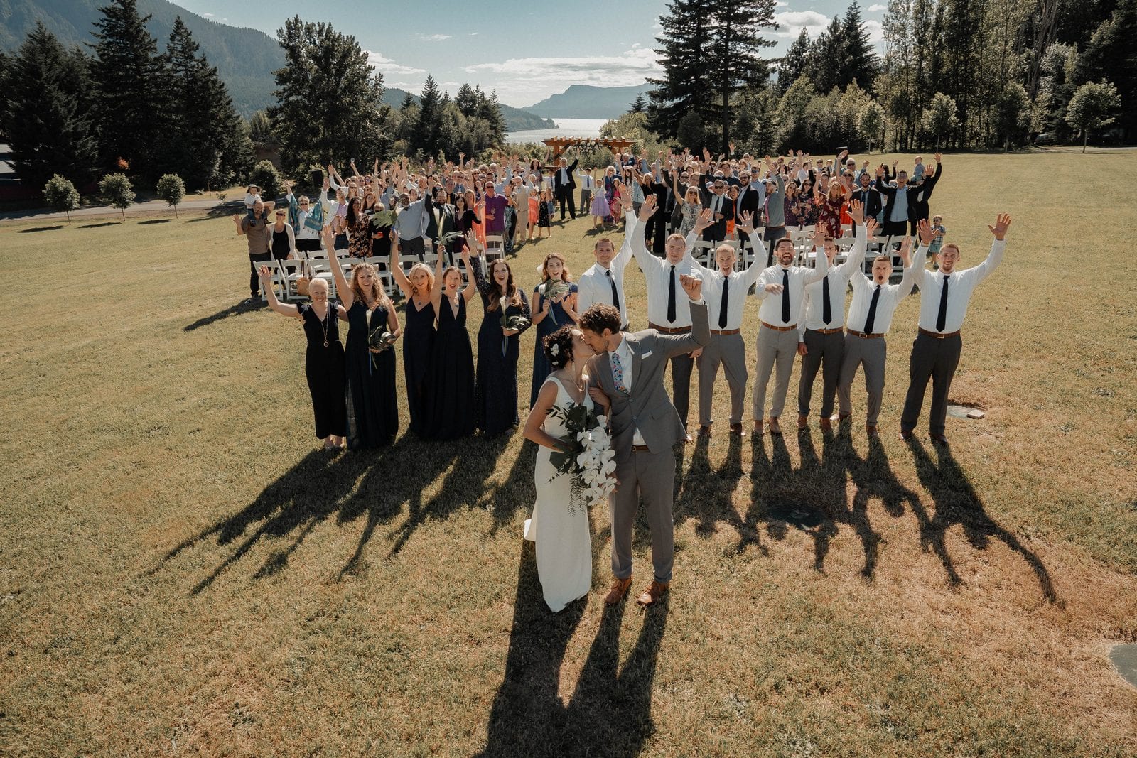The couple kissing as all their guests cheer