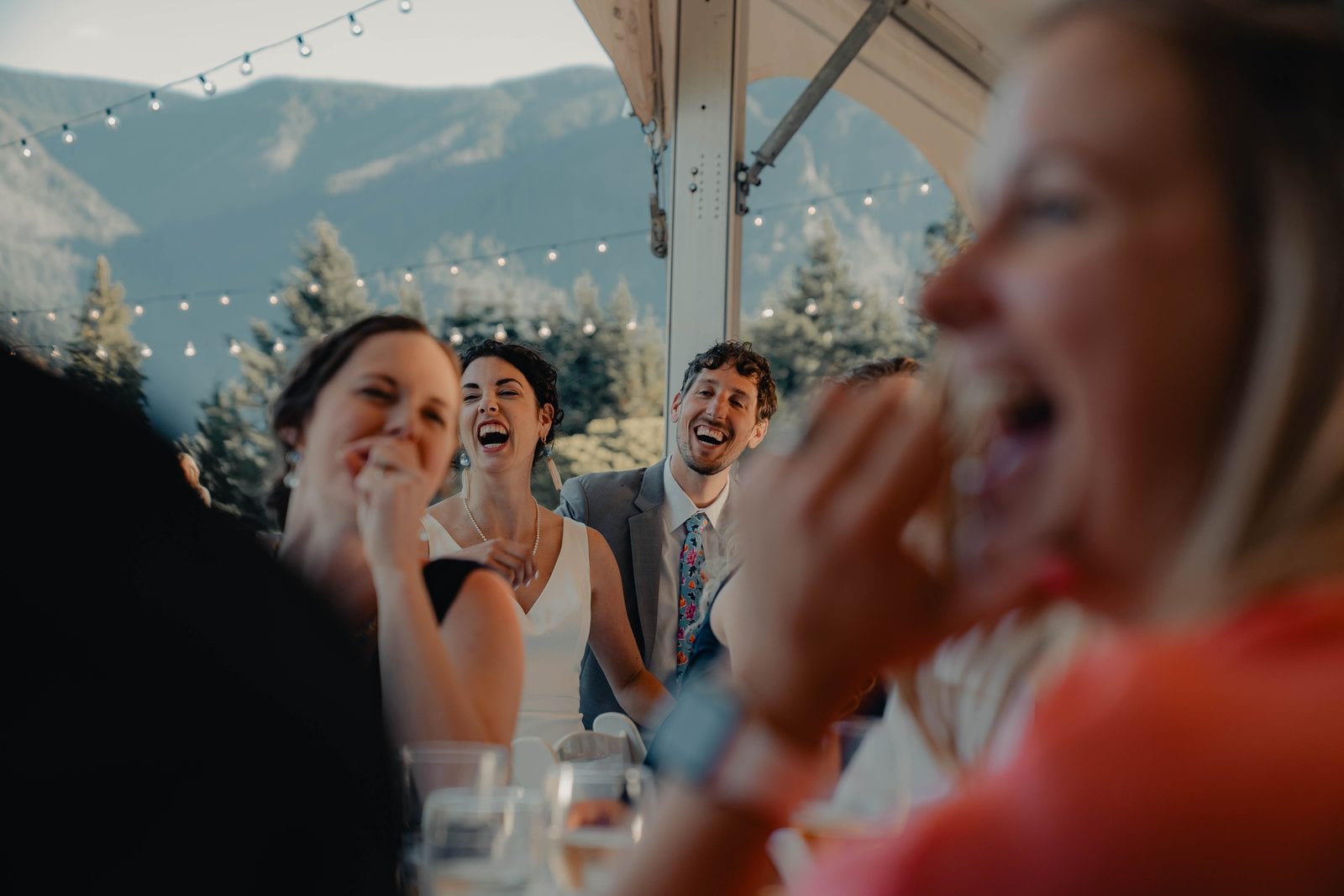 Laughter at the reception table under string lights