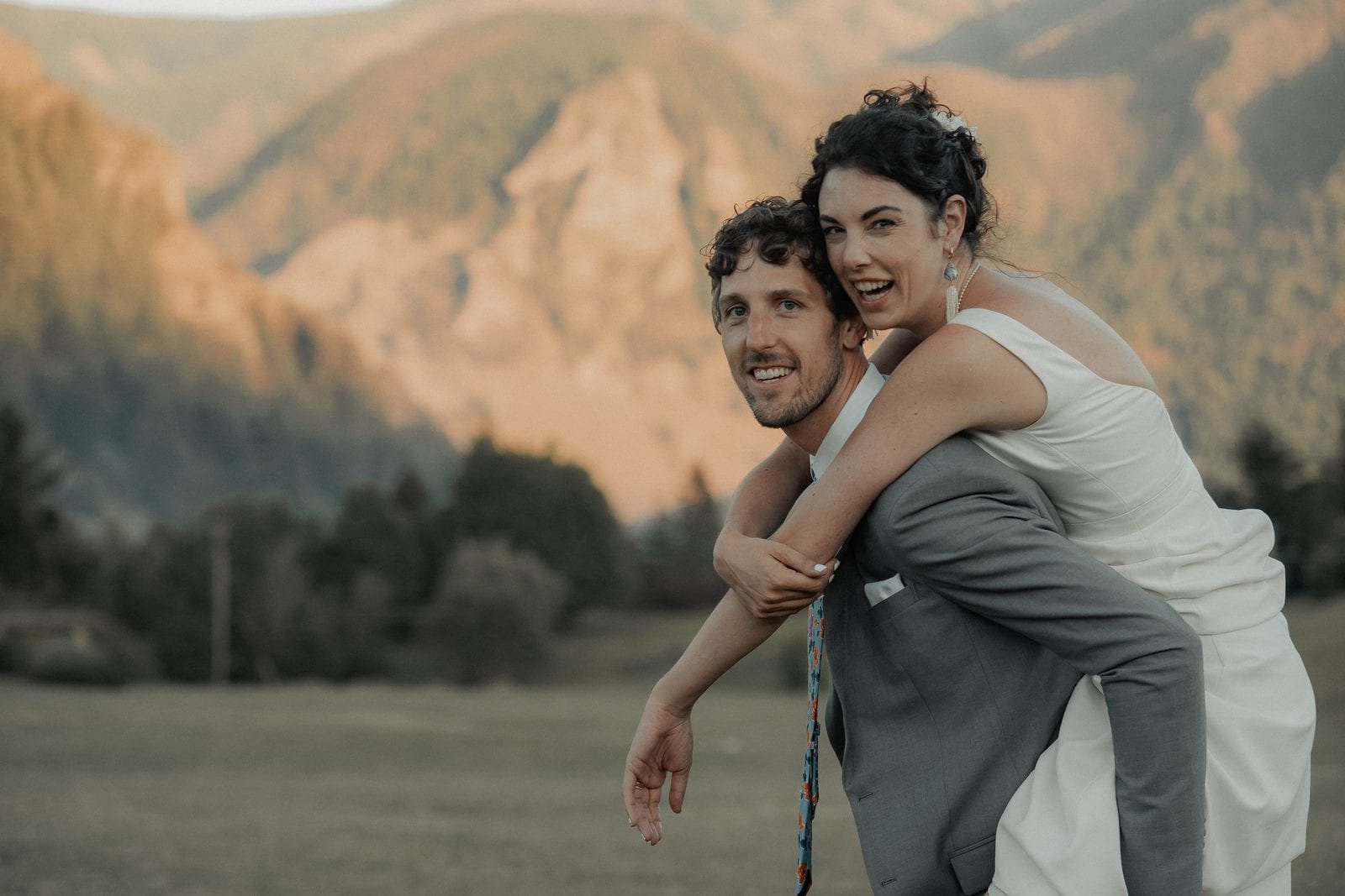 Golden-hour portrait — the groom giving the bride a piggyback ride