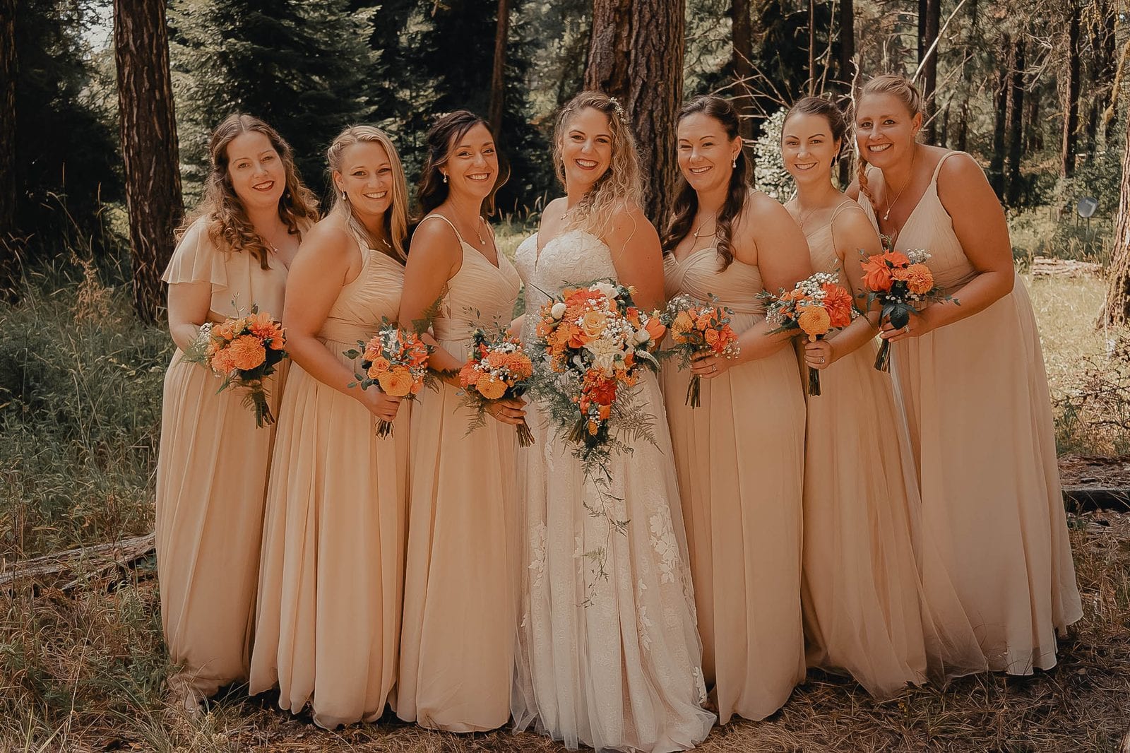 The bridesmaids with their bouquets in the forest