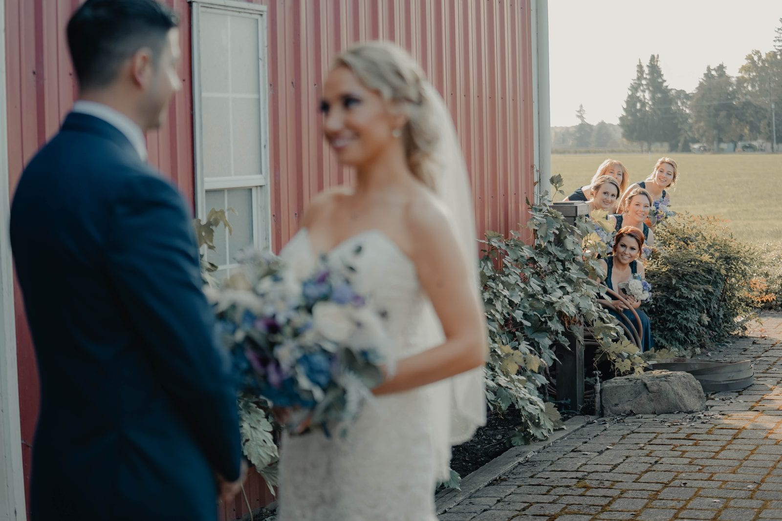 The first look, with bridesmaids watching from the corner