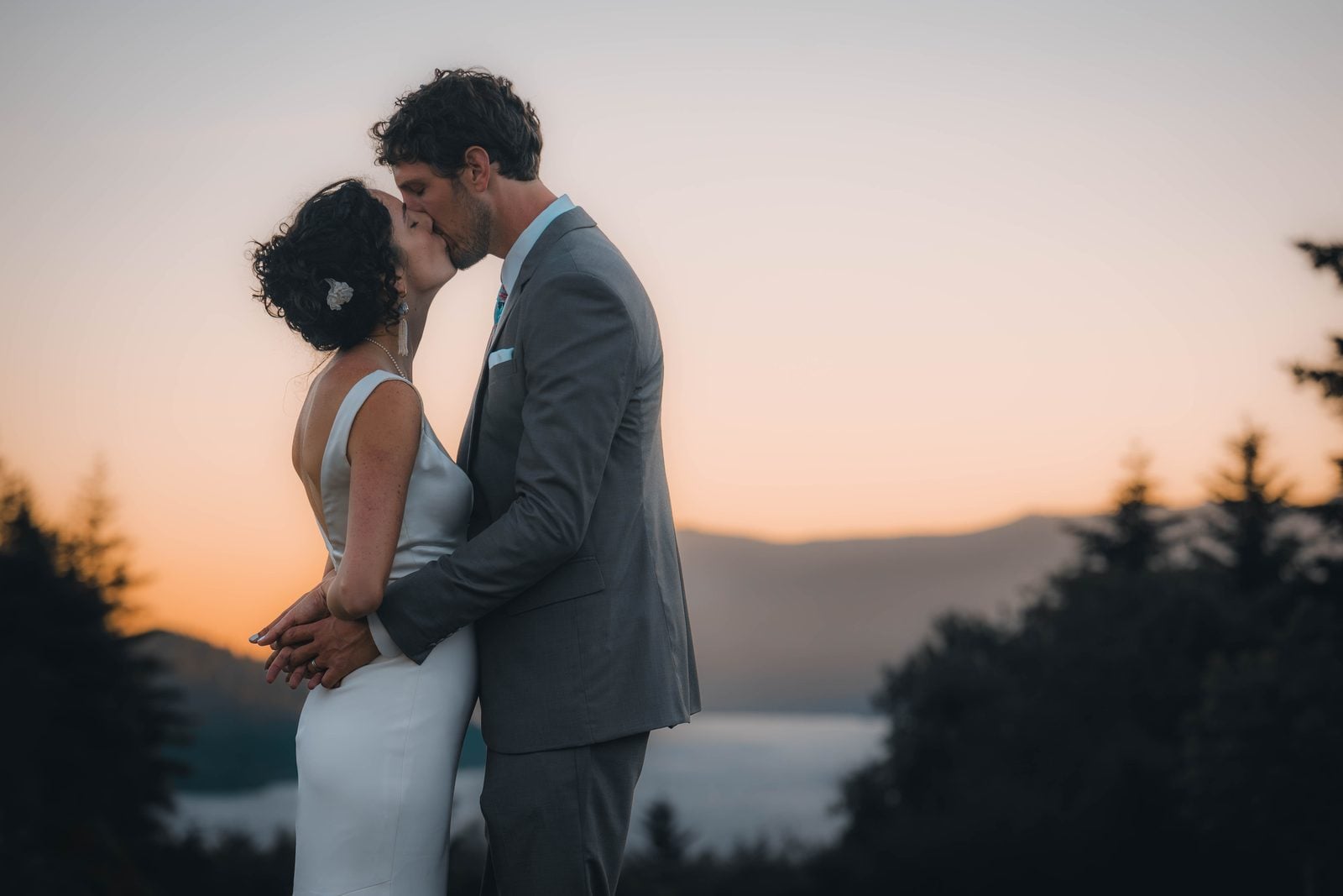 Danny and Sophia sharing a kiss at sunset on their Washington wedding day