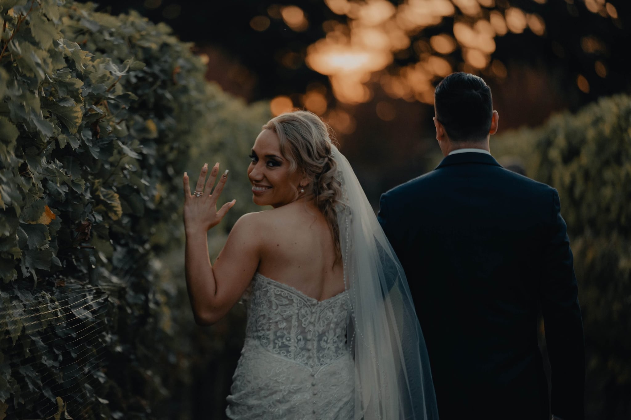Cody and Madeline walking into the vineyard at sunset on their Oregon wedding day